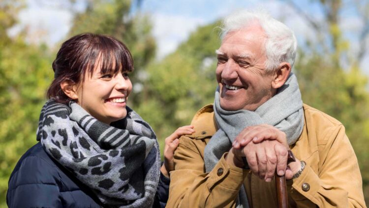 Dynes a dyn yn gwenu